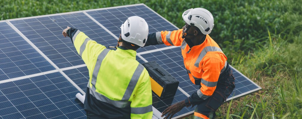 Engineer inspecting solar panels at an agricultural farm, highlighting the importance of system performance and condition in a solar lease buyout transaction.