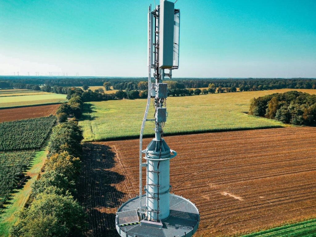 Aerial view of a cellular tower situated on a rural farm property, representing the potential for a lease buyout of wireless infrastructure ground leases.