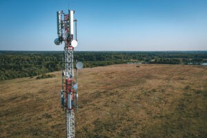 Cell tower standing on a hilltop, representing the financial opportunity of a cell tower lease buyout for landowners.