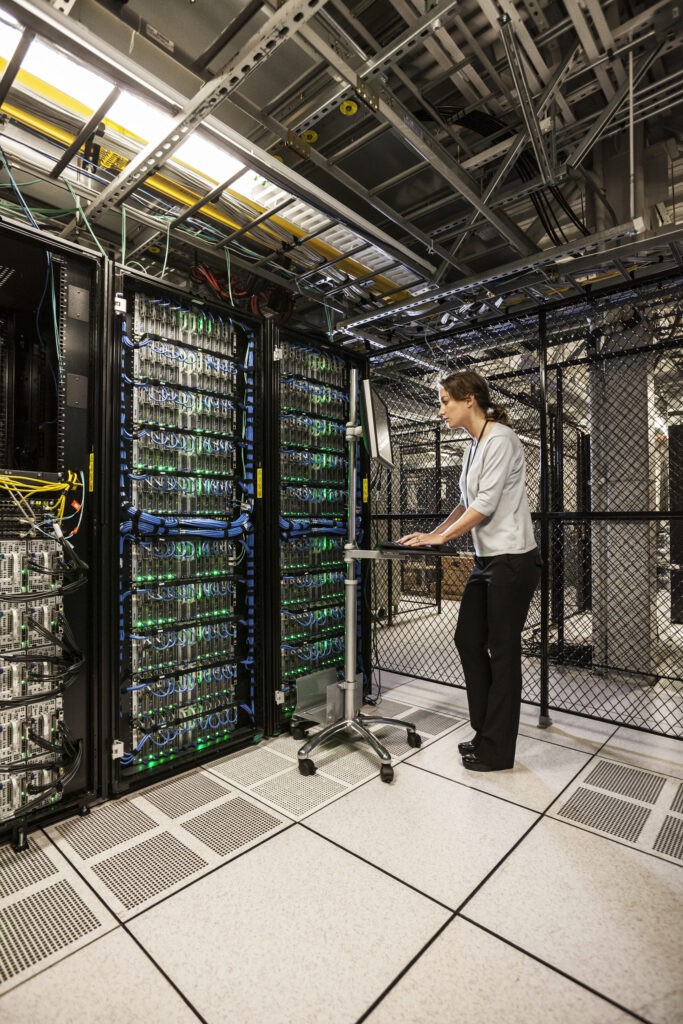 caucasian-woman-technician-working-on-computer-ser-2025-04-03-22-26-50-utc » GAMZs Ground Lease Buyout Woman working in a data center showcasing the role of Digital Infrastructure in shaping property value and investment opportunities.
